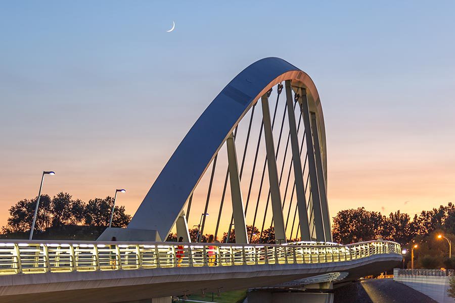About Our Agency - Curved Main Street Bridge in Columbus, Ohio at Sunset, With a Crescent Moon Overhead